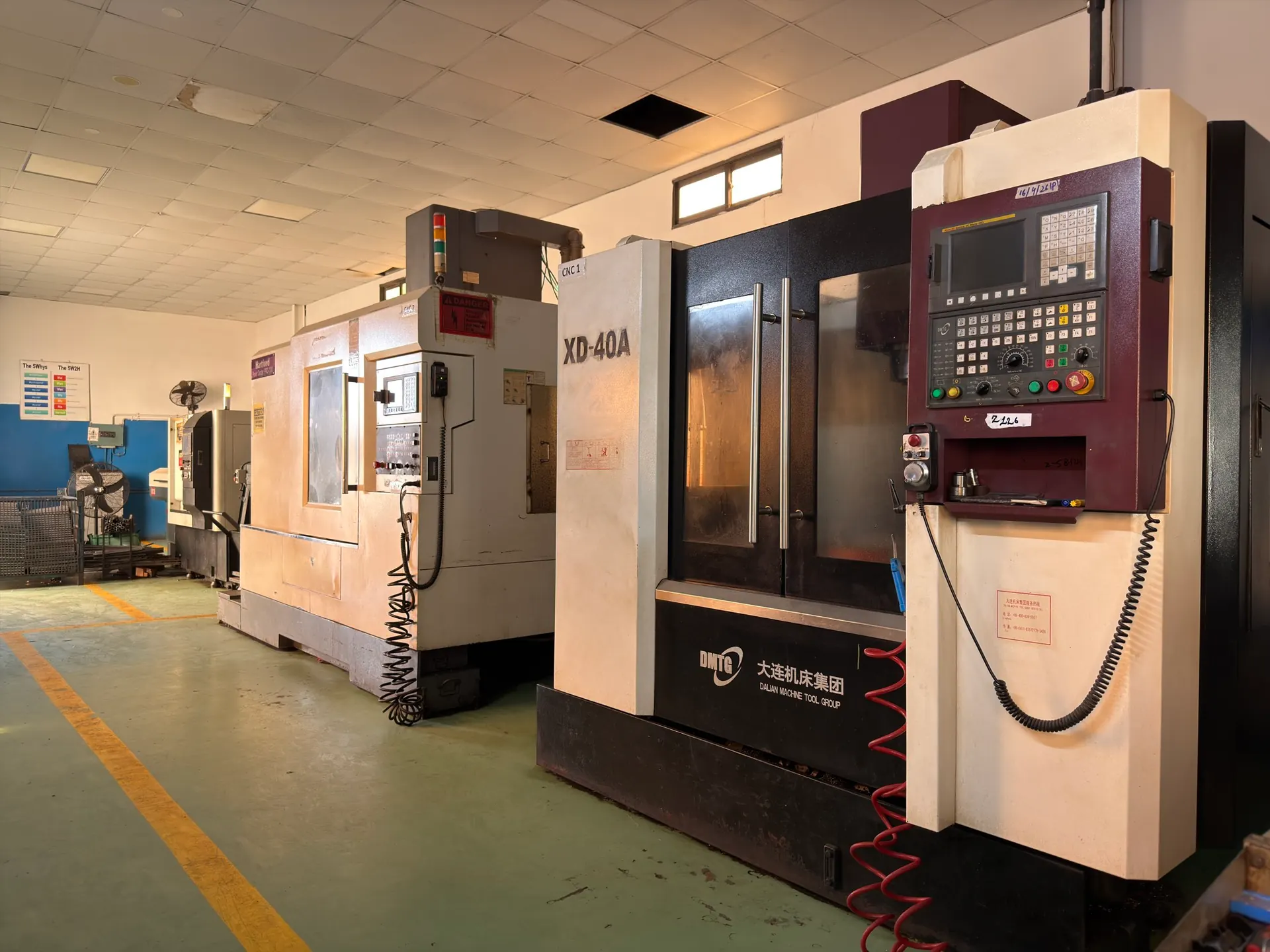 DMTG XD-40A vertical machining centre, CNC 1, with its control panel beside a second machining centre
