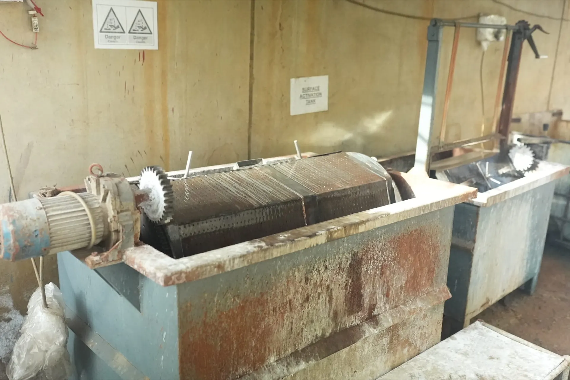 Motor-driven perforated barrel sitting in a surface activation tank