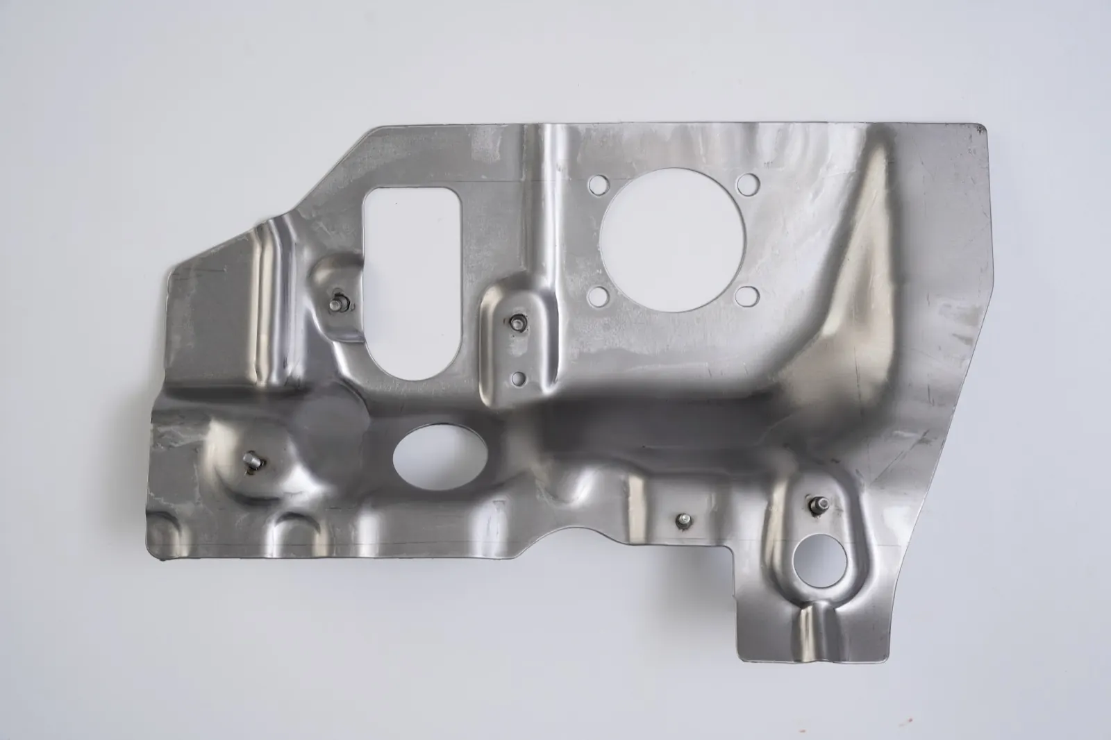 Stamped heat shield panel with welded studs, flanged openings and a four-bolt port